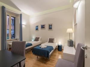 a room with two beds and a table and chairs at The Best Rent - Elegant flat near Colosseum in Rome