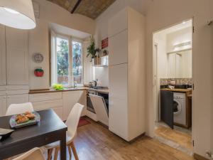 a kitchen with white cabinets and a table and chairs at The Best Rent - Elegant flat near Colosseum in Rome +9 photos