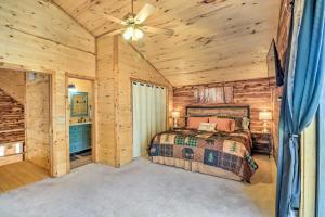una camera da letto in una baita di tronchi con letto e ventilatore a soffitto di Charming Mountain View Cabin about 8 Mi to Dtwn! a Mountain View