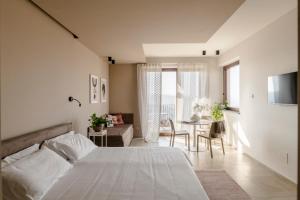 una camera da letto con un letto e un soggiorno di Il Cortile Suites a Diano dʼAlba