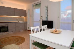 een keuken met een witte tafel en stoelen bij Infinity Apartment by Wonderful Italy in Bellagio