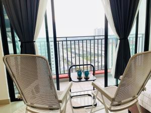 two chairs and a table on a balcony with a view at High Floor studio Austin Regency Mount Austin w Balcony 3 plus 1pax 5 mins AEON in Johor Bahru