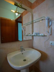 uma casa de banho com um lavatório e um espelho em GH Baraka Village em Scoglitti