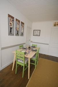 uma sala de jantar com uma mesa e cadeiras verdes em Renovated French Country House for Six - A Home for Your Next Holiday em Hercé