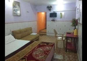 a small room with a bed and a table and a television at Zeal Guesthouse By WB Inn in Kānpur