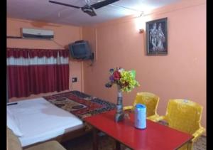 comedor con mesa roja y sillas amarillas en Zeal Guesthouse By WB Inn, en Kānpur