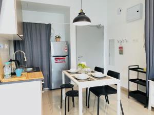 a kitchen with a white table and black chairs at High Floor studio Austin Regency Mount Austin w Balcony 3 plus 1pax 5 mins AEON in Johor Bahru