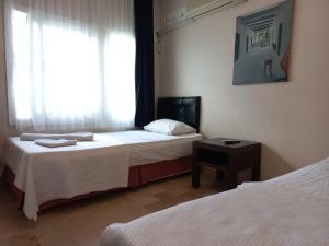 切什梅的住宿－Blue otel çeşme，酒店客房设有两张床和窗户。