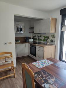 a kitchen with a wooden table and a dining room at Ferienwohnung am Olbasee in Malschwitz