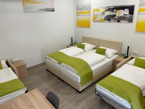 Hotel Garni Ilys Inn في فيلس: غرفة نوم بسريرين عليها بطانيات خضراء