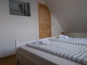 1 dormitorio con 2 camas y puerta de madera en Familienfreundliches ruhig gelegenes perfekt ausgestattetes Ferienhaus, en Boiensdorf