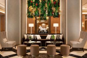 a hotel lobby with a couch and two chairs at The Westin Palace, Milan in Milan
