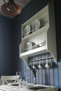 a white cabinet with cups and plates on it at Schönes Appartement in Zierzow mit Grill, Terrasse und Garten in Sietow