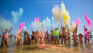 a group of people in the water with colored smoke at Hotel Loris - Valentini Family Village in Bellaria-Igea Marina