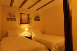 a bedroom with two beds and a lamp and a mirror at Casa Rural Las Dalias con Hidromasaje in Villafranca del Cid