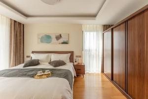 ein Schlafzimmer mit einem großen Bett mit zwei Handtüchern darauf in der Unterkunft Green Court Place Jingqiao Middle Ring Shanghai in Shanghai