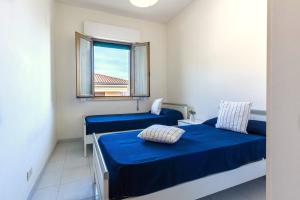 Habitación con 2 camas y ventana en Appartamento Attico Vespucci - MyHo Casa, en Tortoreto Lido