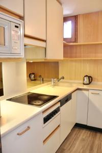 a white kitchen with a sink and a stove at Appartamento Emanuel in Livigno