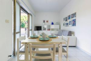 cocina y comedor con mesa y sillas en Appartamento Attico Vespucci - MyHo Casa, en Tortoreto Lido