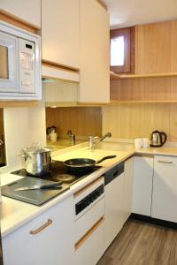 una cucina con lavandino e piano cottura forno superiore di Appartamento Emanuel a Livigno