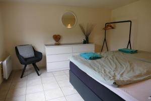 ein Schlafzimmer mit einem Bett, einem Stuhl und einem Spiegel in der Unterkunft Ferienhaus für 2 Personen ca 45 m in Negast, Ostseeküste Deutschland Rügen in Samtens