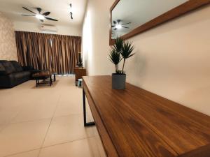 una sala de estar con una mesa con una maceta. en Banana Homestay Kuching - P' Residence, en Kuching