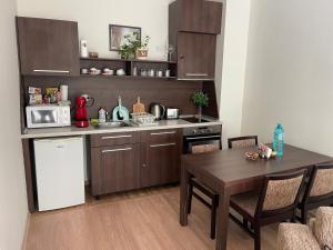 cocina con mesa, microondas y nevera en Мия 2 Спа хотел Свети Спас, en Velingrad 27 fotos más