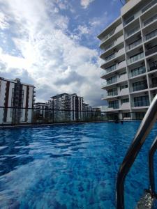 a swimming pool in front of a building at Banana Homestay Kuching - P' Residence in Kuching