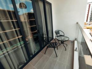 a balcony with two chairs and a table on it at Banana Homestay Kuching - P' Residence in Kuching