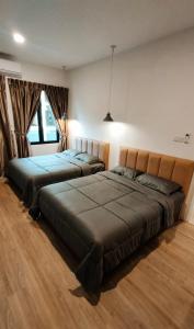 a bedroom with two beds and a large window at Banana Homestay Kuching - P' Residence in Kuching