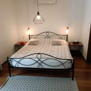 een bed in een kamer met twee nachtkastjes en twee tafels bij Villa CITRONS VERTS dans un parc arboré vue mer in Cap Skirring