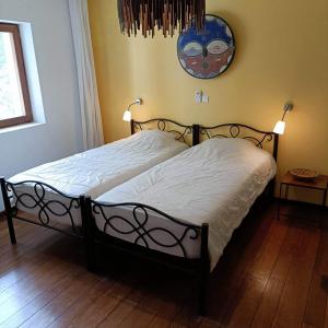 uma cama num quarto com um relógio na parede em Villa CITRONS VERTS dans un parc arboré vue mer em Cap Skirring