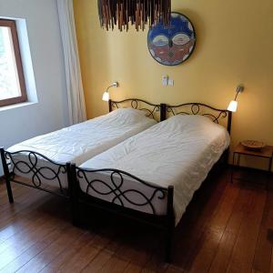 a bed in a bedroom with a clock on the wall at Villa CITRONS VERTS dans un parc arboré vue mer in Cap Skirring