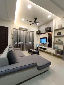 a living room with a couch and a ceiling fan at Melaka Homestay with pool 4BR Semi-D,BBQ,KTV,Billiard 15pax DeStarryVilla in Malacca