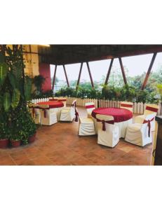 a group of tables and chairs in a building at Hotel Kolam, Dehradun in Dehradun