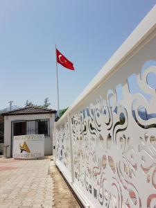 un drapeau battant au-dessus d'un bâtiment avec un mur orné de graffitis dans l'établissement Agva Apart Otel, à Kemer