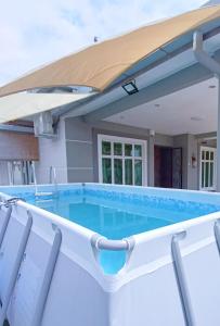 piscina con ombrellone e sedie di Melaka Homestay with pool 4BR Semi-D,BBQ,KTV,Billiard 15pax DeStarryVilla a Malacca