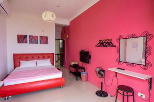 Dormitorio rojo con cama y espejo en Meet Bay B&B, en Xiyu