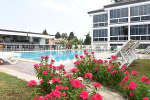 a swimming pool with pink flowers in front of a building at Agva Apart Otel in Kemer