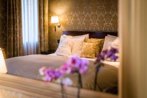 a bedroom with a bed with purple flowers on it at Ca Maria Adele in Venice