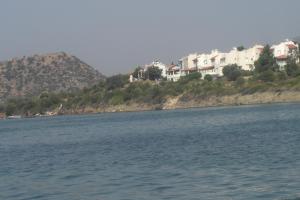 a large body of water with houses on a hill at Mavi Ege Villalari in Çeşme