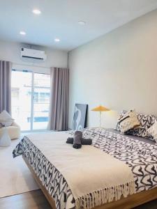 a bedroom with a bed with a black and white blanket at BKK Villa/Huaikwang China Twon in Bangkok