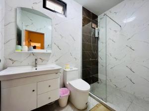 a bathroom with a toilet and a glass shower at BKK Villa/Huaikwang China Twon in Bangkok