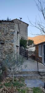 un antiguo edificio de piedra con una puerta y una casa en La maison de Barbara, en Mars