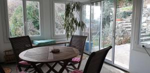 comedor con mesa, sillas y ventanas en La maison de Barbara, en Mars