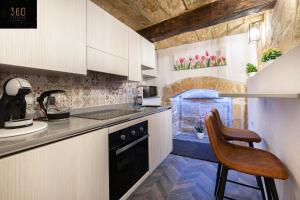 a kitchen with white cabinets and a chair in it at 1BR Charming townhouse in capital city with WIFI by 360 Estates in Valletta