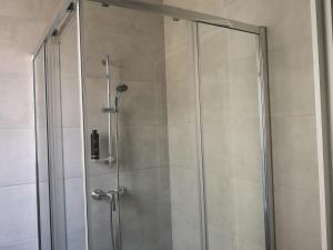 um chuveiro com uma porta de vidro na casa de banho em Dghajsa GUEST HOUSE em Senglea