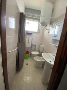a bathroom with a toilet and a sink at Complesso Mosaico NON FORNISCE BIANCHERIA DA LETTO,NON FORNISCE ASCIUGAMANI NON FORNISCE PRODOTTI IN GENERE, appartamenti arredati come da foto, Per il Check in Agenzia Ferro Viale Francesco Petrarca 391 lido Adriano Ra in Lido Adriano +15 photos