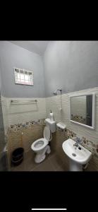 a bathroom with a toilet and a sink at Casa Harmony in Tanah Merah