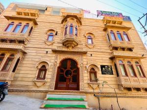 un edificio de madera con puerta roja y ventanas en Hotel Garh Vila, en Jaisalmer